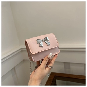 Detailed shot of pink PU leather mini chain bag with silver butterfly bow accessory