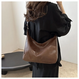 Detailed back view of model wearing a brown leather patchwork hobo bag for daily commute