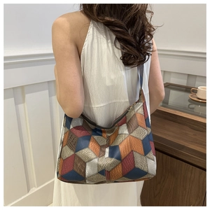 Detail of colorful 3D geometric patchwork on shoulder bag with embossed textures