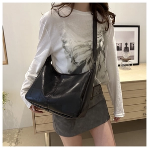 Close-up of large capacity black leather crossbody bag with lychee texture and wide strap
