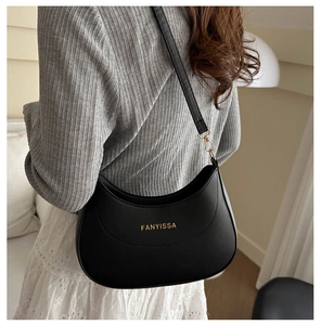Vue détaillée du sac demi-lune noir avec logo doré et bandoulière réglable pratique