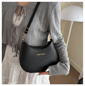 Détail du sac bandoulière croissant noir FANYISSA avec logo doré et boucle réglable
