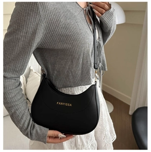 Close-up of a black crescent shoulder bag with golden Fanyissa logo and leather strap