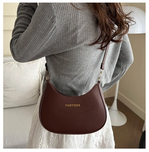 Détail du sac bandoulière en demi-lune en cuir marron rouge avec impression dorée