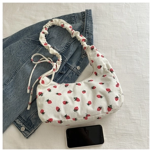 Detalle de bolso de pana blanco con estampado de fresas y asa fruncida