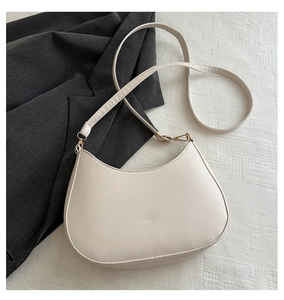 Détail du sac hobo crème en cuir mat lisse avec des boucles en métal doré élégant