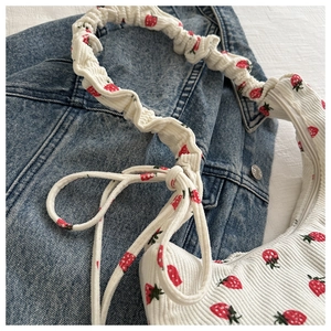 Detalle del bolso de pana blanco con estampado de fresas y correa fruncida tipo scrunchie