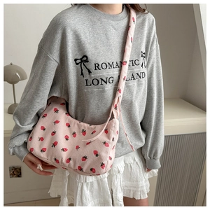 Detalle de bolso bandolera de pana rosa con estampado de fresas en modelo