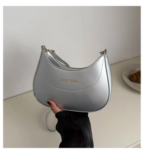 Détail du sac demi-lune argenté métallisé avec lettrage de marque doré élégant
