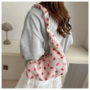 Detail of pink corduroy shoulder bag with strawberry print and scrunchie strap