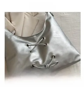 Detail view of silver PU leather tote bag featuring modern cross lacing and metal eyelets