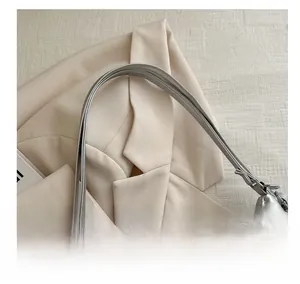Close-up of curved metallic silver handle on a stylish faux leather tote bag