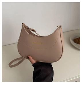 Détail du sac bandoulière demi-lune FANYISSA en similicuir beige avec logo doré gravé