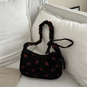Retro strawberry embroidery corduroy underarm bag with ruffled handle on white sofa