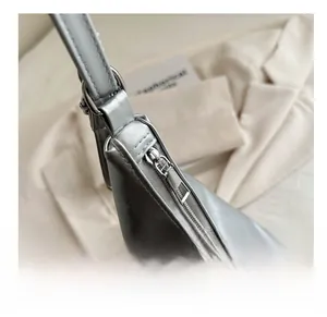 Close-up of smooth silver metal zipper and hardware on silver synthetic leather tote bag