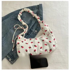 Detail of corduroy shoulder bag with strawberry print and ruched strap design