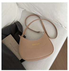 Détail du sac demi-lune avec logo doré, cuir mat marron et bandoulière réglable
