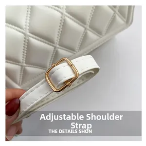 Detail of adjustable shoulder strap with golden metal buckle on white quilted handbag
