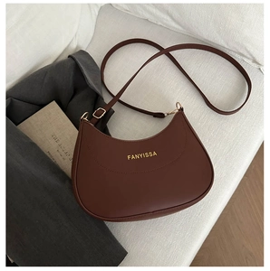 Détail d'un sac demi-lune marron foncé avec logo doré et bandoulière réglable