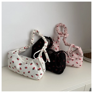 Close-up of strawberry print corduroy handbags in white black and pink with bow details