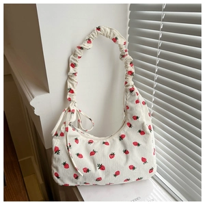 Primer plano de bolso hobo de pana blanca con estampado de fresas y asa rizada detalle