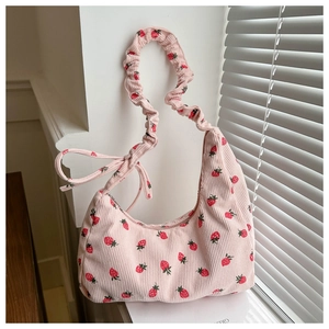 Detalle del bolso de pana rosa con estampado de fresas y correa fruncida con lazo