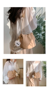Detail of beige bucket bag with drawstring, fashion tag and cute white lamb charm