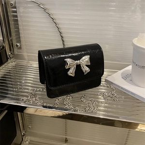 Glossy black patent leather crossbody bag with silver butterfly buckle and chain strap