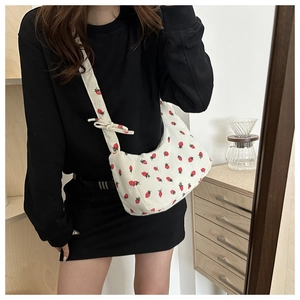 Detalle de bolso de hombro en pana blanca con estampado de fresas y lazo decorativo