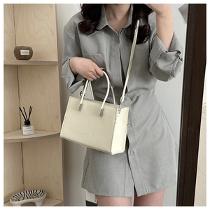 Detail of off-white lychee leather handbag with MOISHI logo and detachable shoulder strap