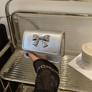 Silver metallic mini crossbody bag with large bow detail and sleek chain strap for women