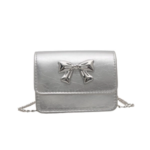 Minimalist silver crossbody bag with metallic crinkle texture and butterfly bow detail