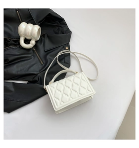 Detailed close-up of white quilted PU leather crossbody bag with light gold hardware