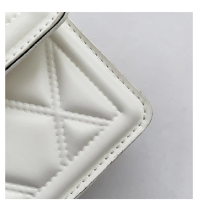 Detailed macro view of white quilted faux leather texture with X-shaped diamond stitching