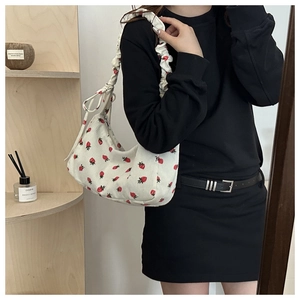 Detalle del bolso de pana blanca con fresas rojas y correa con lazo fruncido