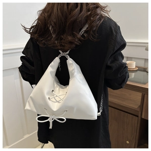 Detail of white moon hobo bag with lace-up straps and decorative ribbon bow details