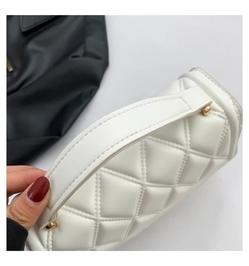 Detail of white quilted handbag showing high-quality stitching and gold hardware accents