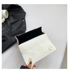 Interior view of white crossbody bag showing storage capacity and golden magnetic snaps