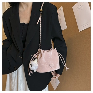 Roze fluwelen emmertas met kettingriem en pluizige hanger gedragen door een model
