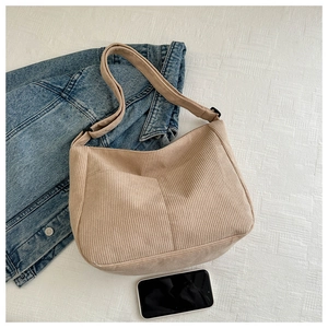 Detail view of a large beige corduroy tote bag showing its texture and spacious opening