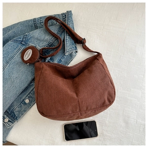 Détail du sac bandoulière en velours côtelé caramel avec sangle et petit porte-monnaie