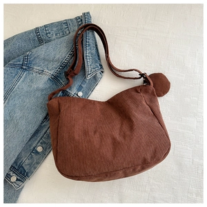 Détail du sac bandoulière en velours côtelé marron foncé avec sangle réglable et poche