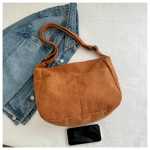 Detailed view of brown corduroy crossbody bag featuring dual front pockets and large capacity