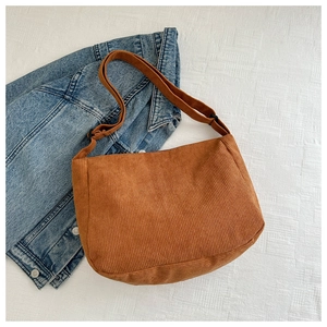 Detailed macro view of the caramel corduroy fabric and adjustable strap of the sling bag