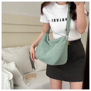 Detail of light green corduroy tote bag with large pocket and cute puppy charm