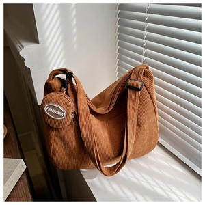 Close-up of caramel corduroy shoulder bag with vertical texture and small round coin purse