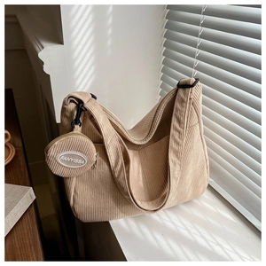 Close-up of beige corduroy texture on dumpling bag with mini round pouch detail