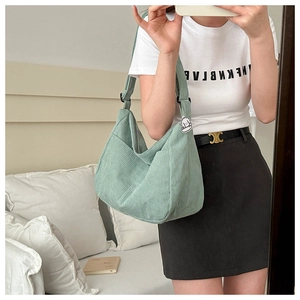 Detail of light green corduroy hobo bag with adjustable strap and cute dog charm