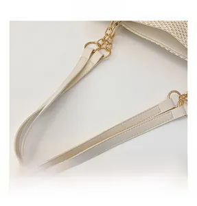 Detailed view of the off-white leather shoulder strap with gold chain links and stitching