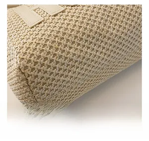 Close-up of beige straw texture and H-shaped leather patch on the shoulder tote bag